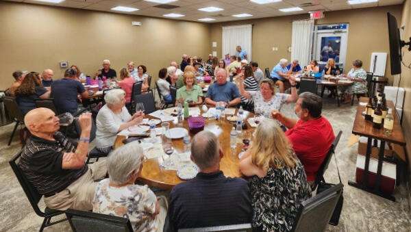 A table of people sampling wine