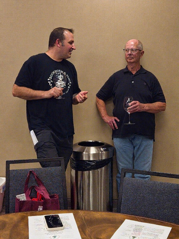 Two men discuss the wine